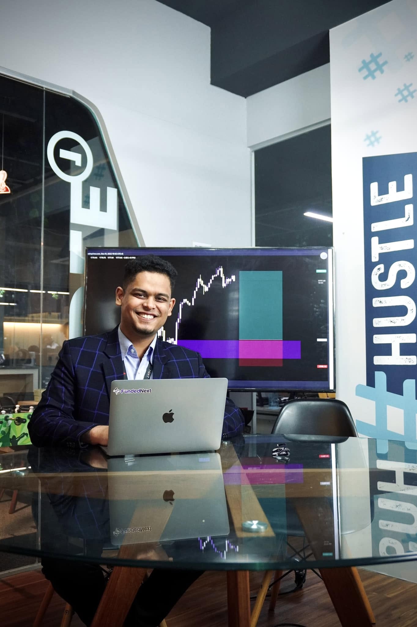 Rifat smiling with his laptop in the FundedNext office